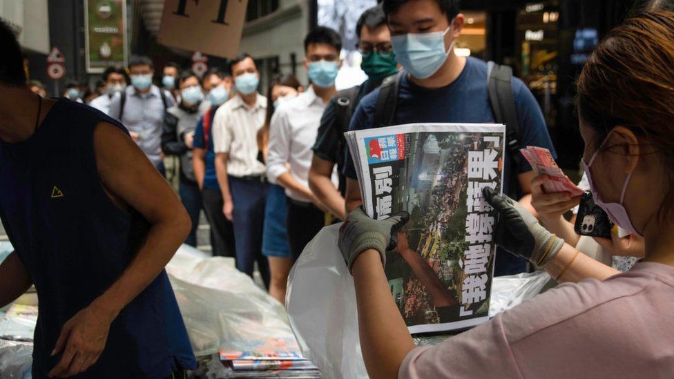 People queue to buy the last edition of Apple Daily