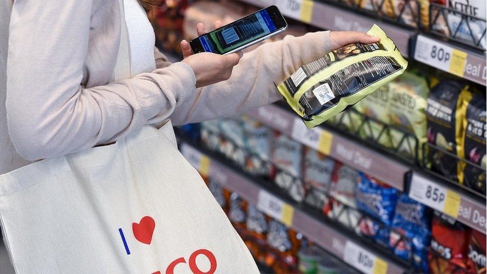 Image caption, Tesco has opened a check-out free store where customers use the app to choose groceries and leave with them