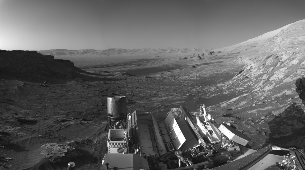 Марсоход Curiosity НАСА использовал свои черно-белые навигационные камеры для съемки панорам этой сцены в два часа дня. 
Это был вид в 4:10 вечера по местному марсианскому времени. 