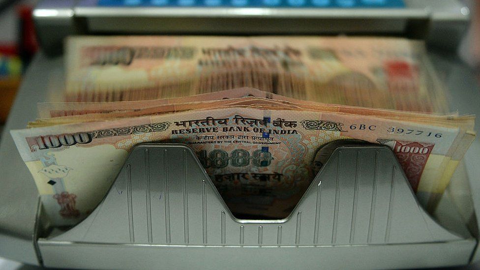 An automatic machine counts Indian Rupee currency notes at a shop in Mumbai.