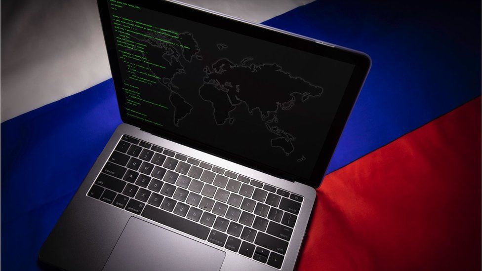 laptop with russian flag behind
хакер