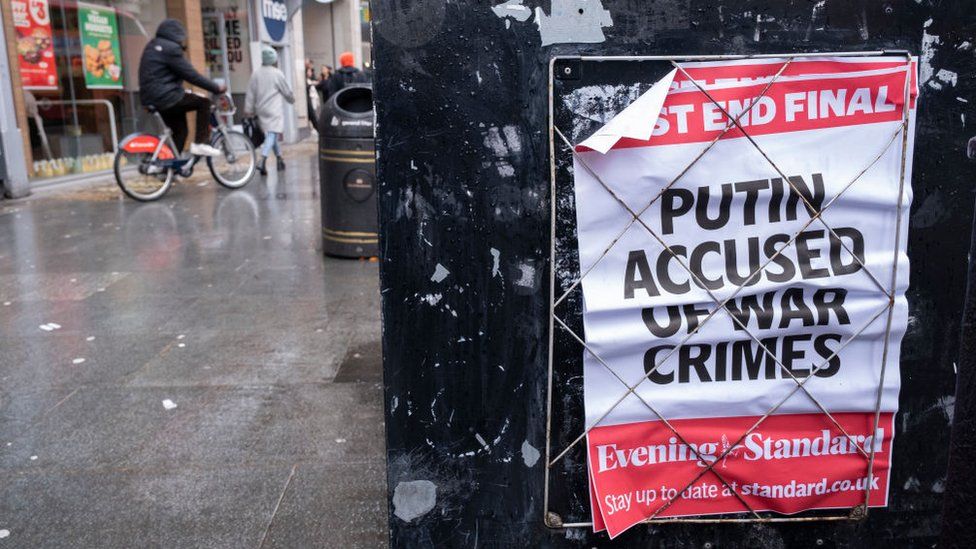 Фотография газетного заголовка в Лондоне с надписью "Путин обвиняется в военных преступлениях". технологические компании 