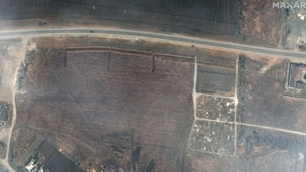 На спутниковом снимке компании Maxar показаны четыре участка линейных рядов могил под города Мариуполь