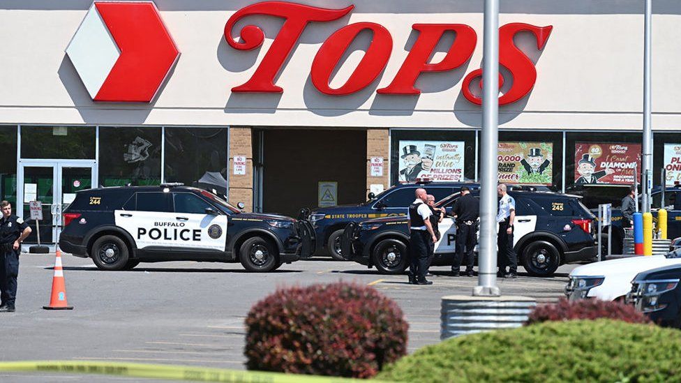 Полицейские машины и лента у супермаркета Tops в Буффало, штат Нью-Йорк, где произошла стрельба