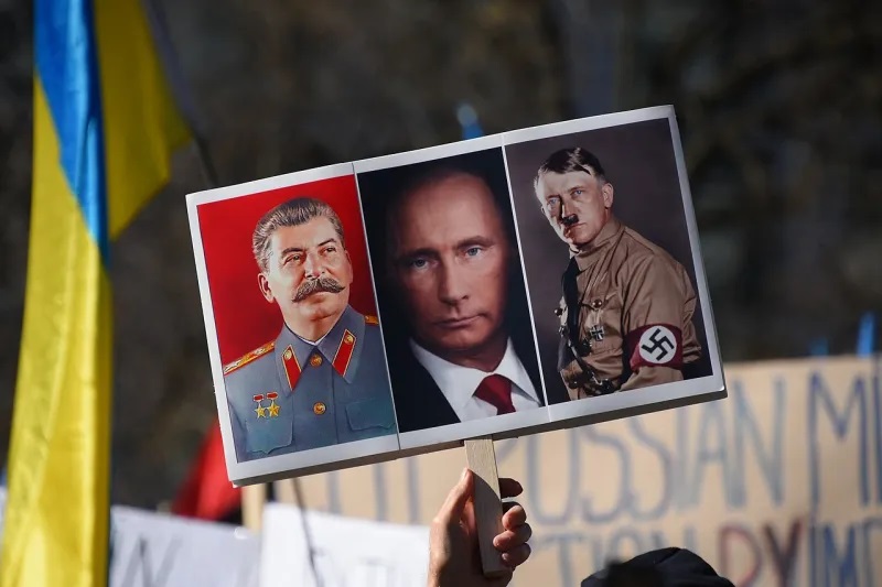 Рашизм: Новое слово, родившееся в результате вторжения России в Украину 1 Плакат с изображениями Иосифа Сталина, президента россии владимира путина и Адольфа Гитлера во время акции протеста против российского вторжения в Украину. Рашизм
