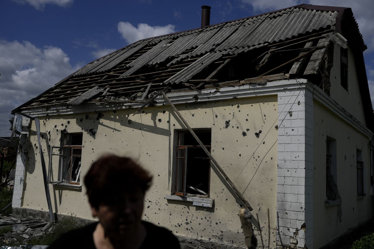 Женщина стоит возле своего дома в Ирпене, который был разрушен в результате обстрела.