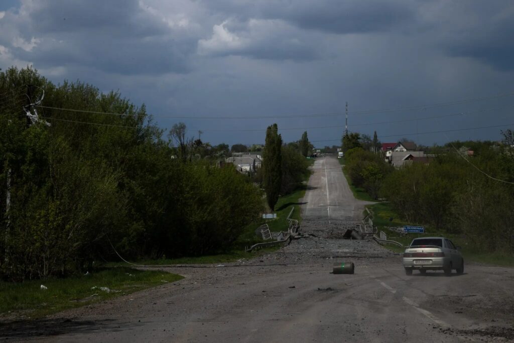 Одна деревня зараз: артиллерийская война в Украине 9 Автомобиль, принадлежащий колонне с гуманитарной помощью, у разрушенного моста на дороге в Руска Лозова.