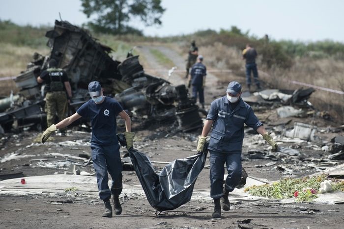 Работники скорой помощи несут тело жертвы с места крушения рейса 17 авиакомпании Malaysia Airlines в 2014 году возле села Грабове, Украина.
ФОТО: ЕВГЕНИЙ МАЛОЛЕТКА/АССОШИЭЙТЕД ПРЕСС