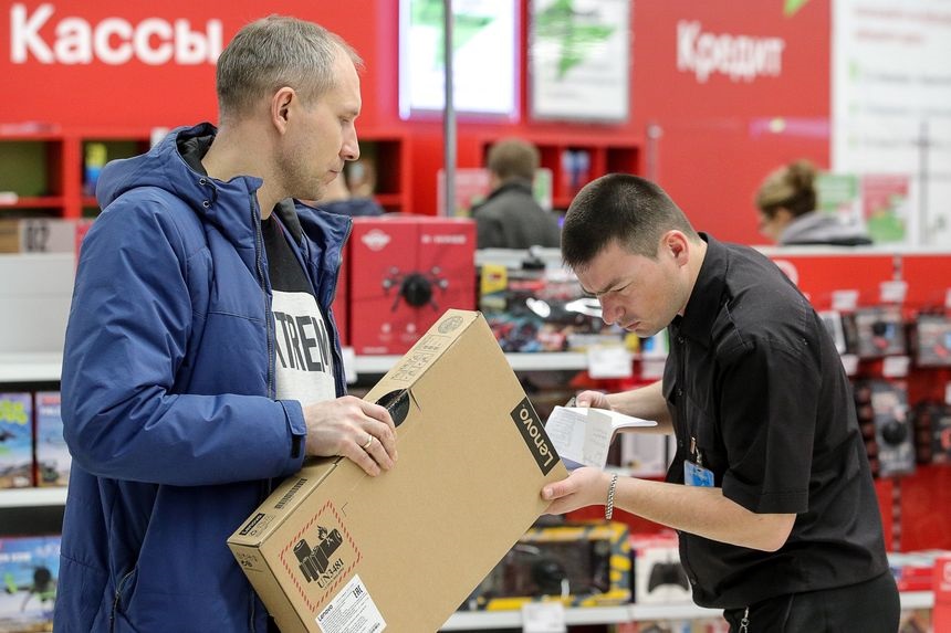 Мужчина покупает ноутбук Lenovo в магазине в москве в марте.