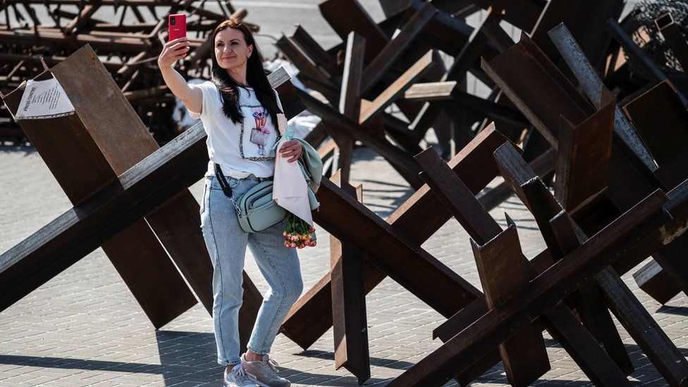 , The new normal: A woman takes a selfie by anti-tank barricades in Kyiv