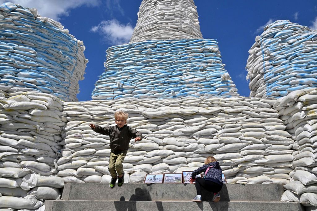 Киев. Дети прыгают и играют вокруг стены из мешков с песком