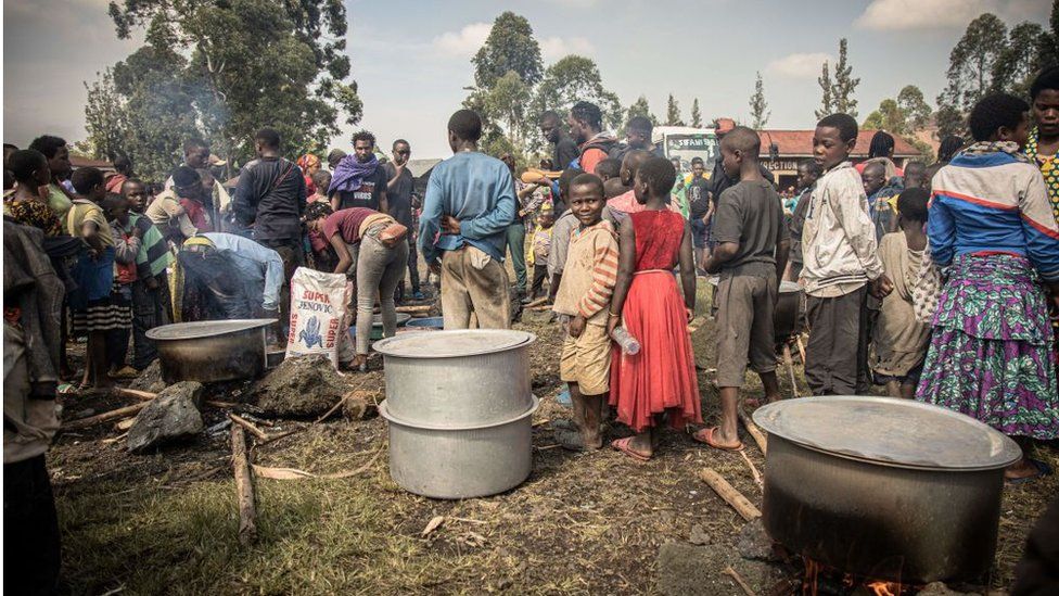 Volunteers prepare meals for Internal displaced people, fleeing the recent clashes between M23 rebels and Congolese soldiers, at a camp in Kanyarushinya north of Goma