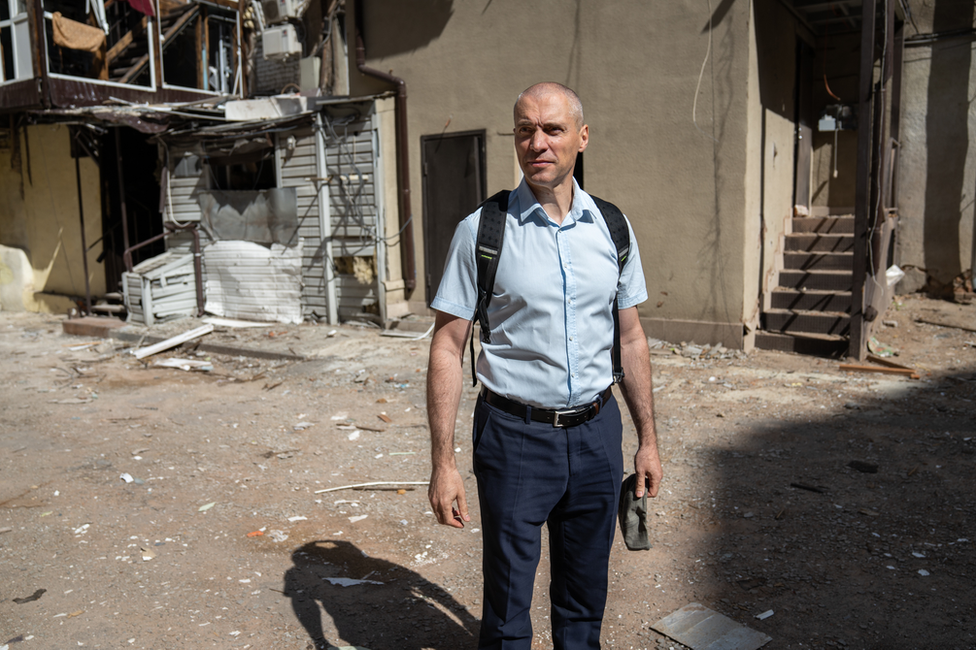 , Denis Masliy, of the regional prosecutor's office, in the courtyard of a building damaged by a missile strike.