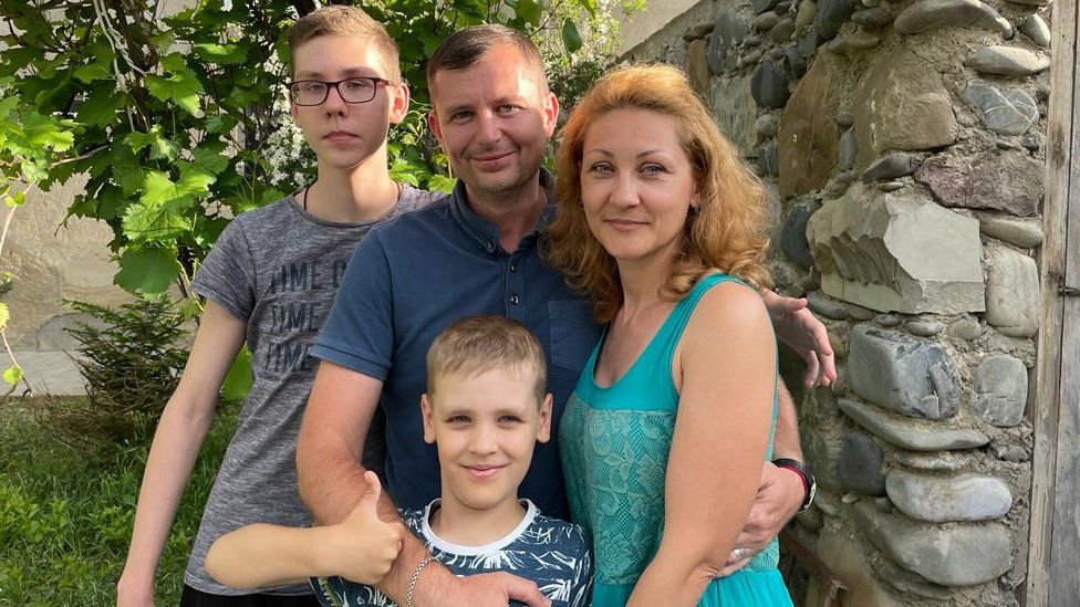 , Oleksandr (centre), his wife Nadia (right) and sons Vlad (left) and Dmytro (bottom) at their new house in Tbilisi