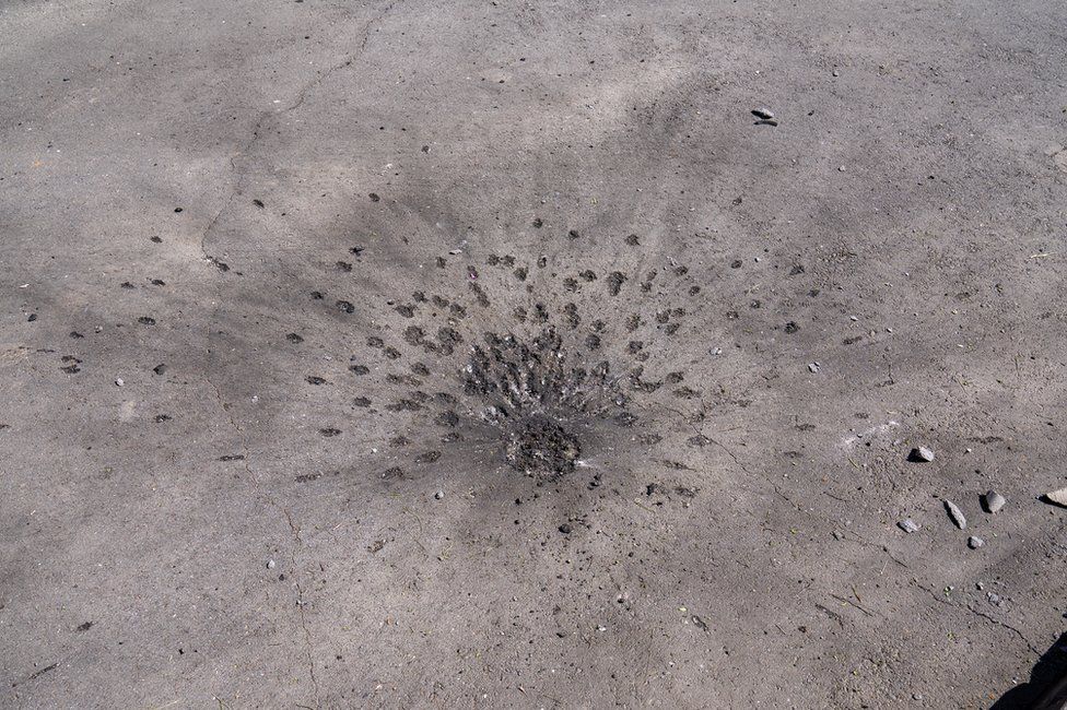 , The spalling pattern created by cluster bomb impacts, seen in a Kharkiv residential neighbourhood (Joel Gunter/BBC)