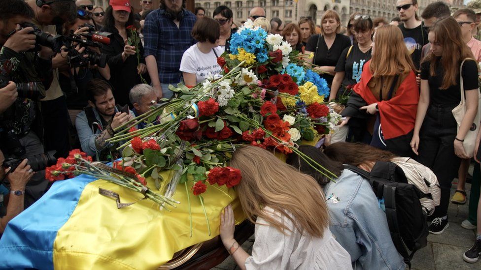 , Mourners pay their respects and leave flowers on the coffin of Roman Ratushny in Independence Square