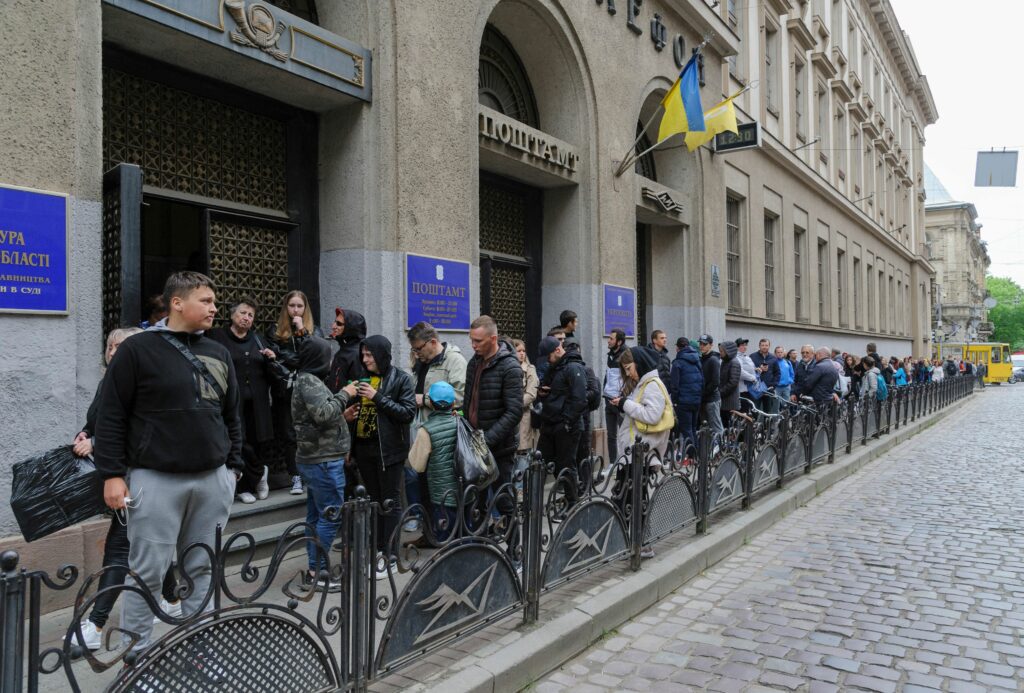 Люди стоят в очереди за почтовыми марками возле почтового отделения во Львове, Украина