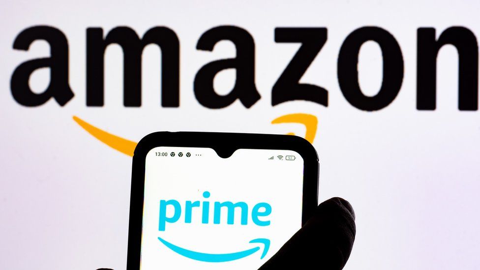 Amazon logo with a Prime logo on a phone in the foreground