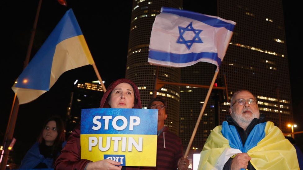 People in the Israeli city of Tel Aviv wave Ukrainian and Israeli flags during a protest against Russia's military invasion of Ukraine in March 2022