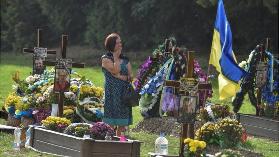 A woman here in tears as she visits the tomb of her relative killed fighting against Russian troops