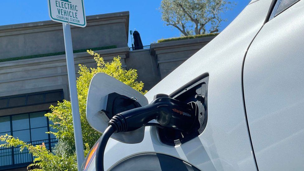 Электромобиль заряжается в штате Калифорния на стоянке.