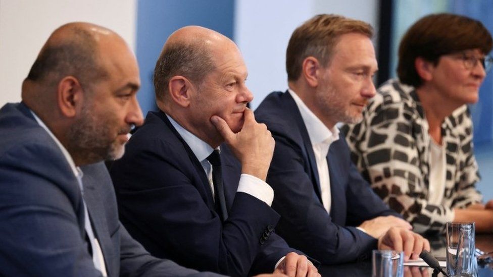Mr Scholz (second left) announced the measures flanked by coalition allies