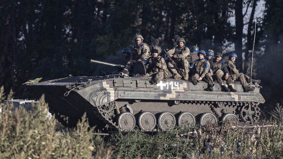 Ukrainian forces patrol a recently recaptured village in the Kharkiv region on Friday