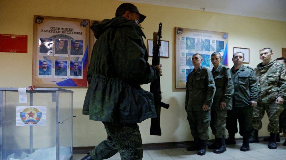 Ballot boxes being guarded by armed soldiers in Luhansk