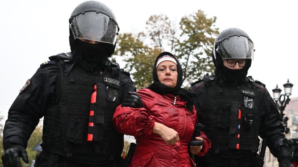 A woman is arrested by Russian police