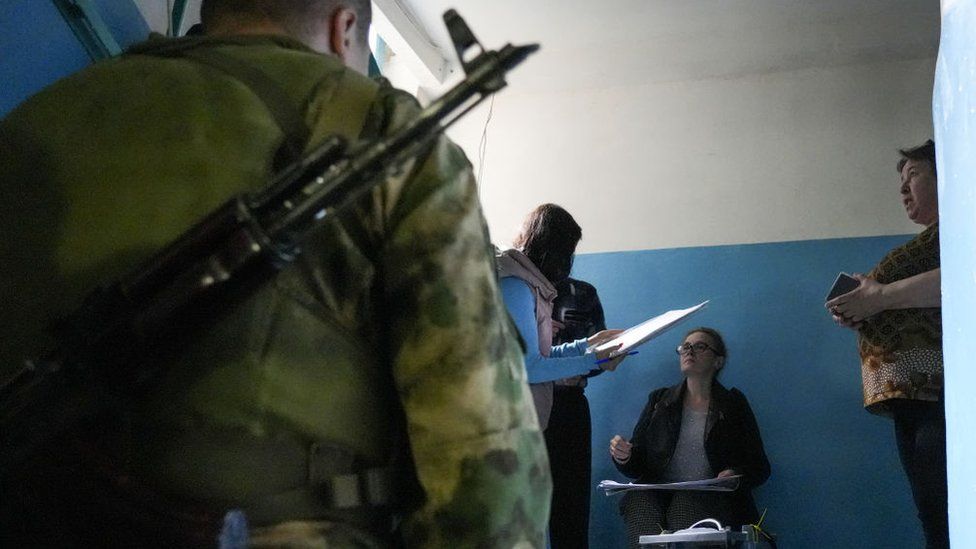 Soldiers are escorting electoral workers going door to door in Donetsk