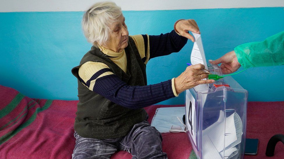 A woman in Russian occupied Zaporizhzhia casts her ballot during voting in a so-called referendum