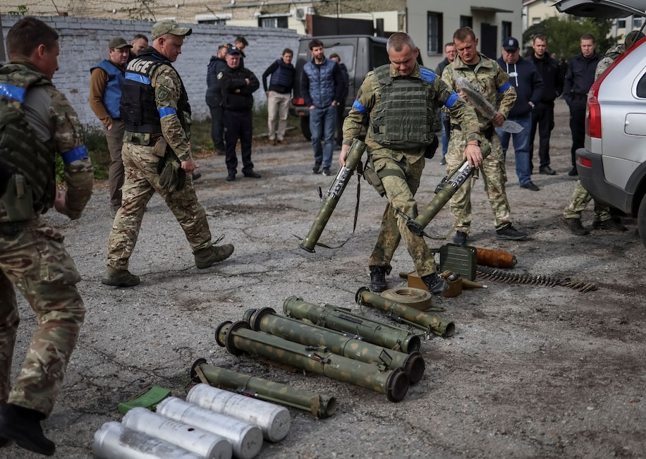 Сотрудники милиции сортируют неразорвавшиеся минные снаряды и оружие после возвращения из села Уды, недавно освобожденного от российской оккупации, в Харьковской области Украины.