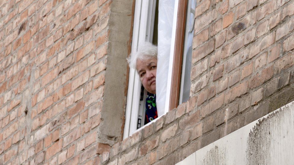 Lyudmila remains in her apartment with her husband, despite the cracked walls and leaking water
