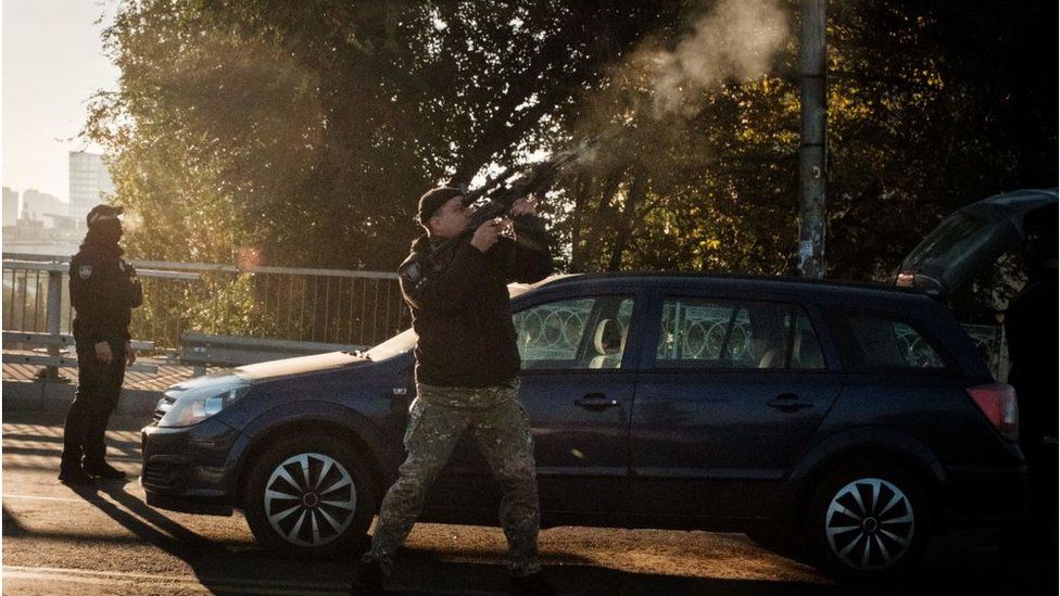 A Ukrainian in Kyiv fires at a drone