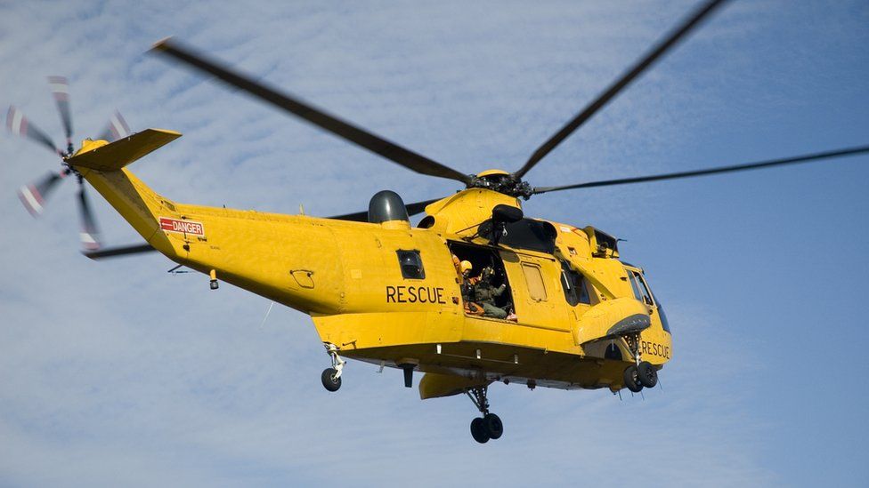 A yellow Sea King rescue helicopter seen in flight