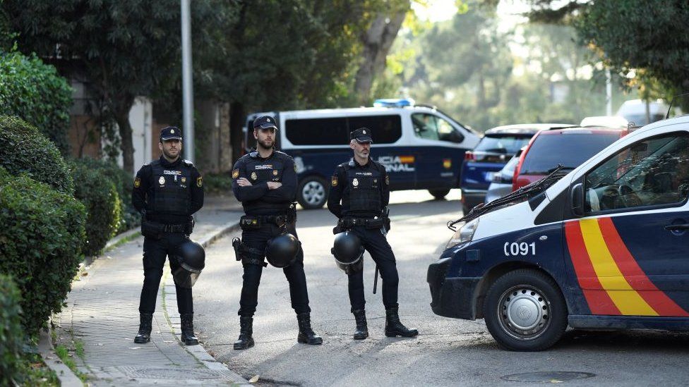 Three Spanish policeman block a road following a letter bomb explosion at the Ukraine's embassy in Madrid on Wednesday