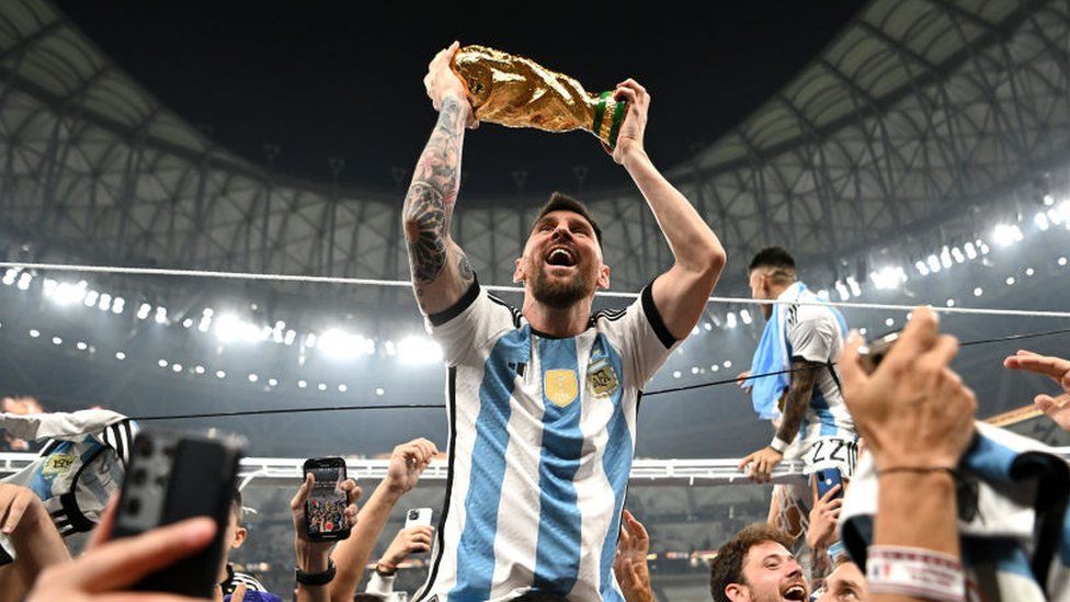 Messi celebrates with the World Cup trophy