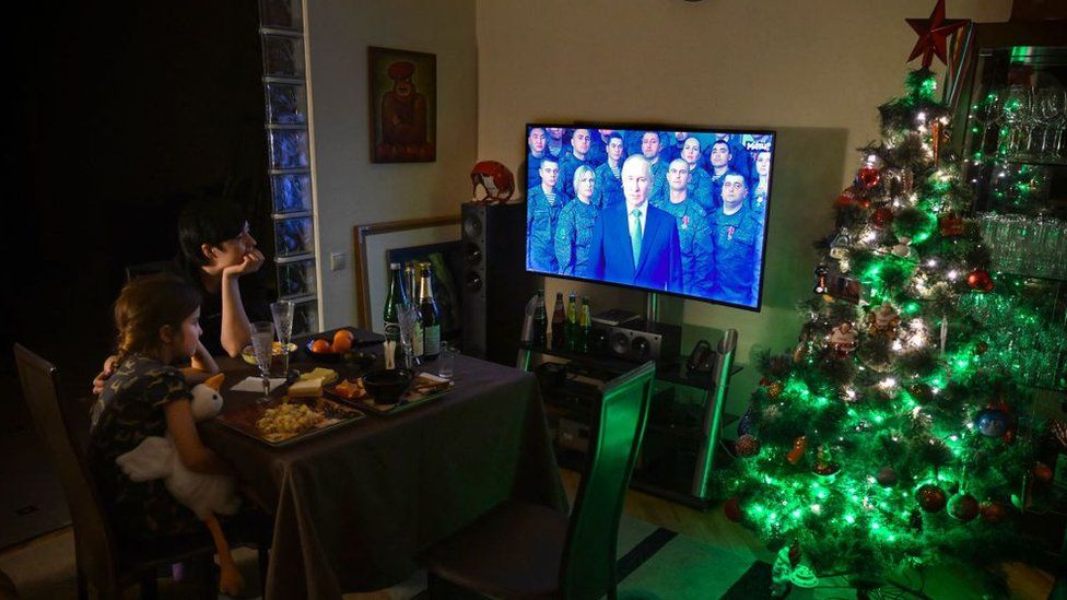 A family watches President Putin's speech
