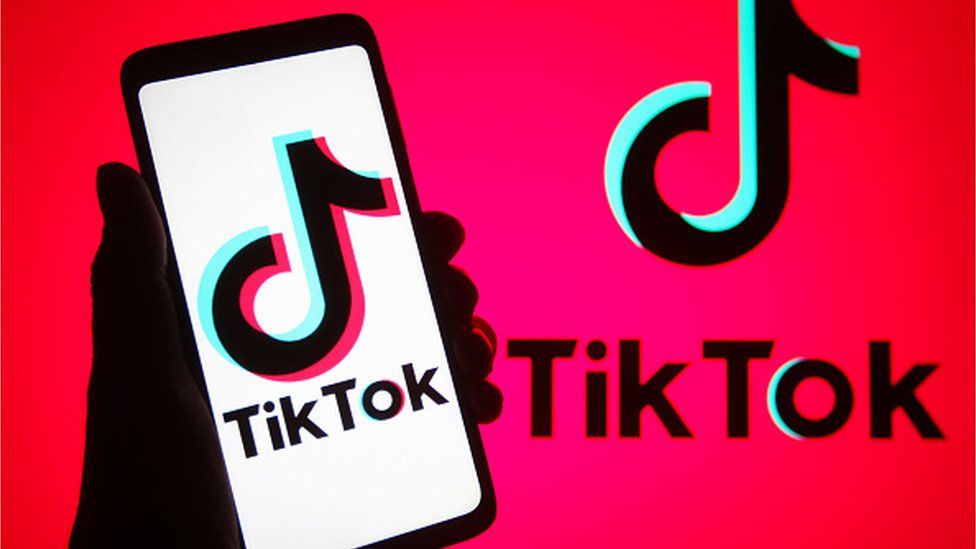 TikTok logo on a phone and in the background
