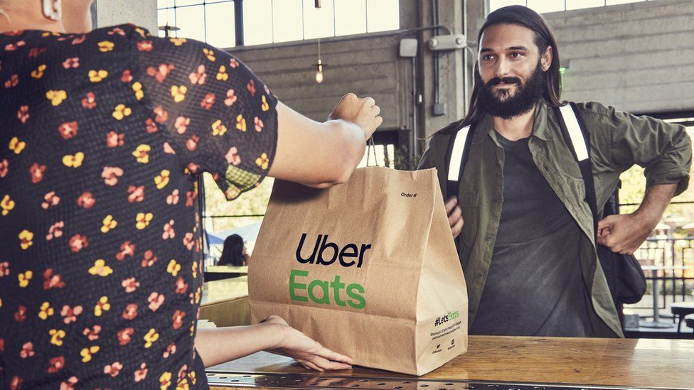 An Uber Eats driver picks food up at a restaurant.