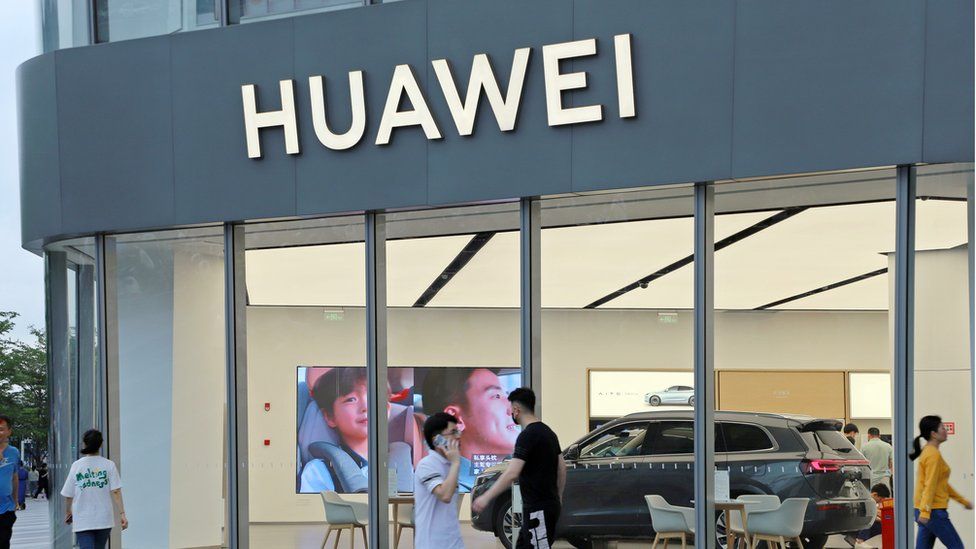 People walk past a Huawei car showroom in Shenzhen, China.