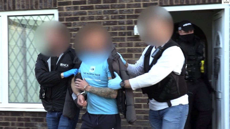 Officers from Britain's National Crime Agency arrest a suspect during raids in Grimsby last month