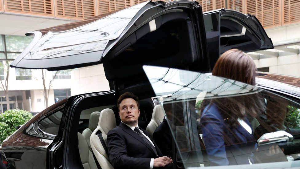 Elon Musk in a Tesla as he leaves a hotel in Beijing on Wednesday