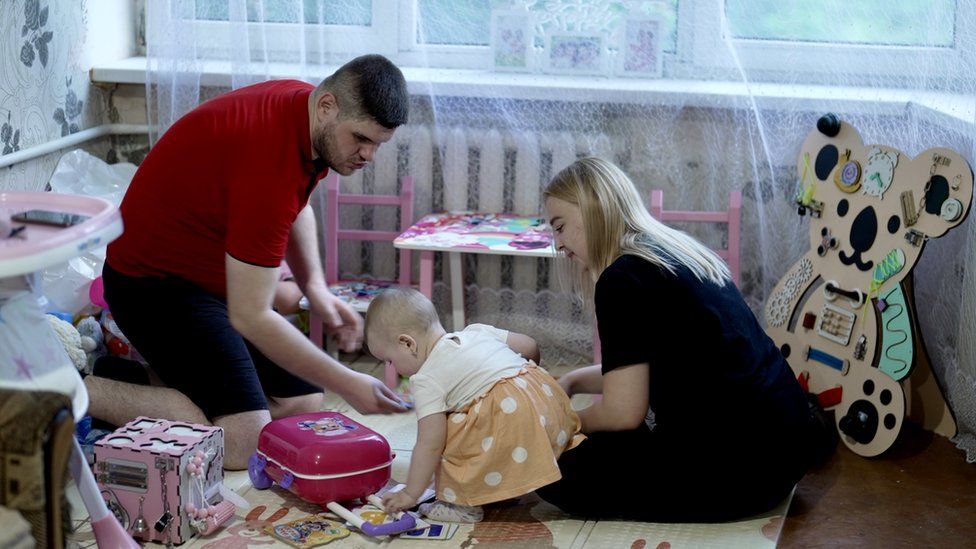 Viktoria (right) with her husband Serhiy and their daughter Eva at their flat in Pokrovsk