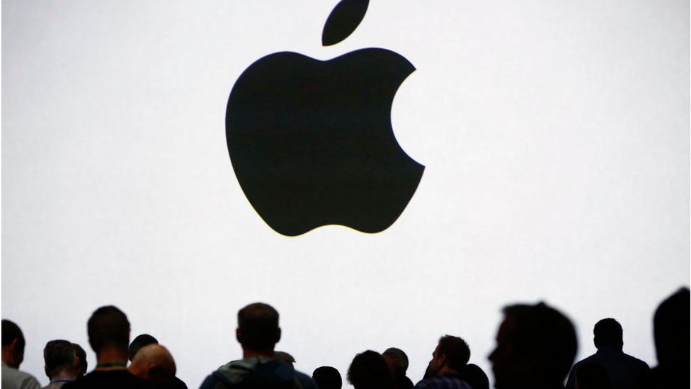 Apple logo projected in front of a crowd