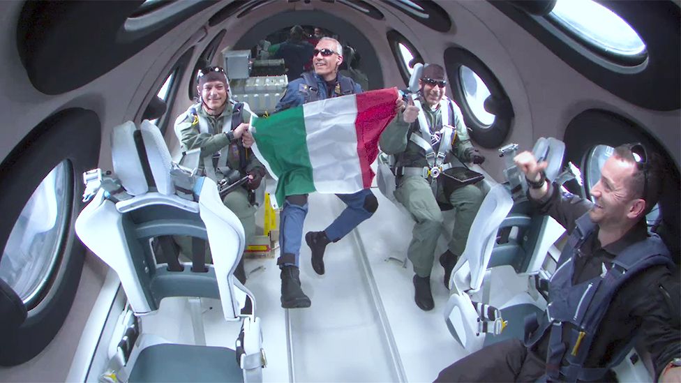 Итальянские члены команды на борту Unity держат флаг своей страны в космосе