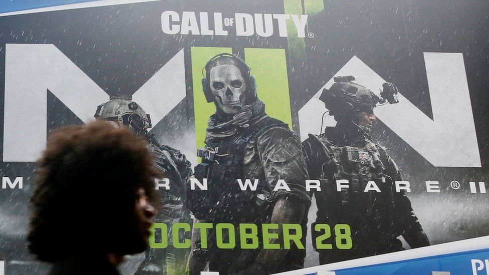 человек проходит мимо плаката Call of Duty