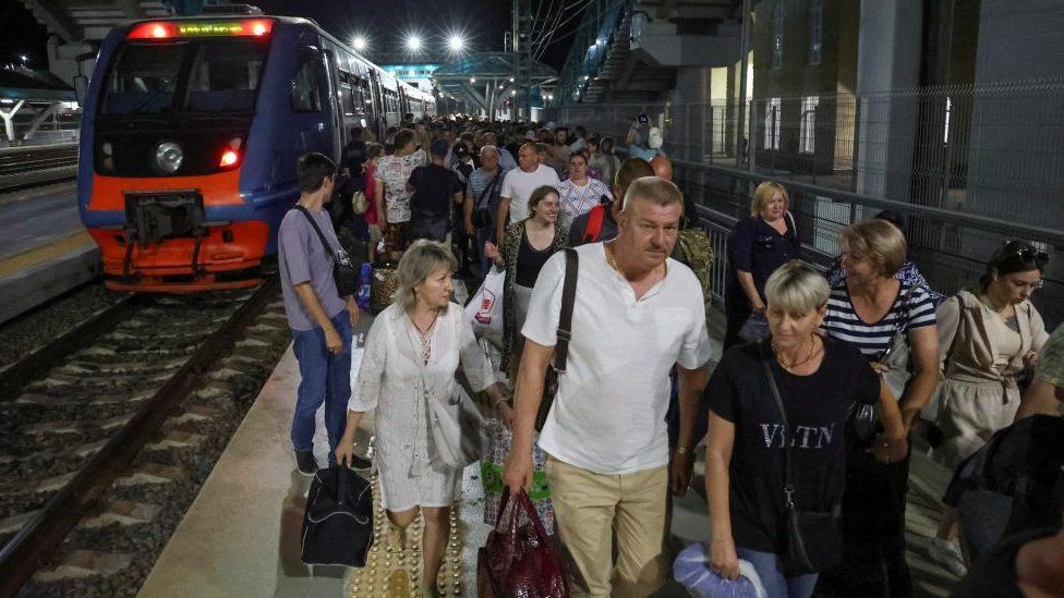 Russian holidaymakers leaving a train which crossed the Kerch Bridge on Monday