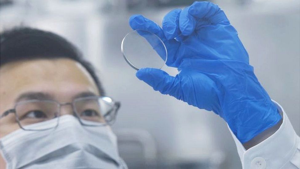 A researcher looks at a gallium oxide wafer
