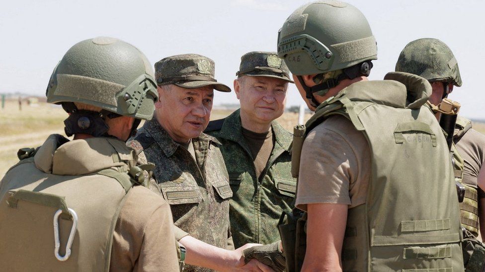 Russia's Defence Minister Sergei Shoigu (centre left) inspects troops at a shooting range in the country's Southern Military District
